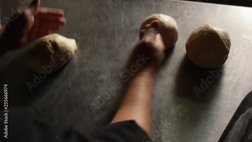 a female chef deflating three pieces of round pizza dough photo