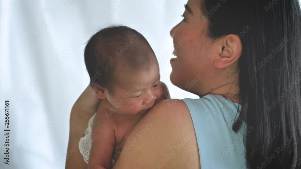 Close up portrait of beautiful young mother asian carrying little baby girl in home and sunlight in the morning. Healthcare, love, relationship concept Close up portrait of beautiful young mother asian carrying little baby girl in home and sunlight in the morning. Healthcare, love, relationship concept