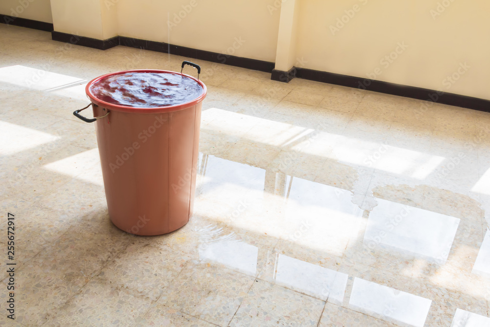 water leak drop interior office building in red bucket from Ceiling and ...