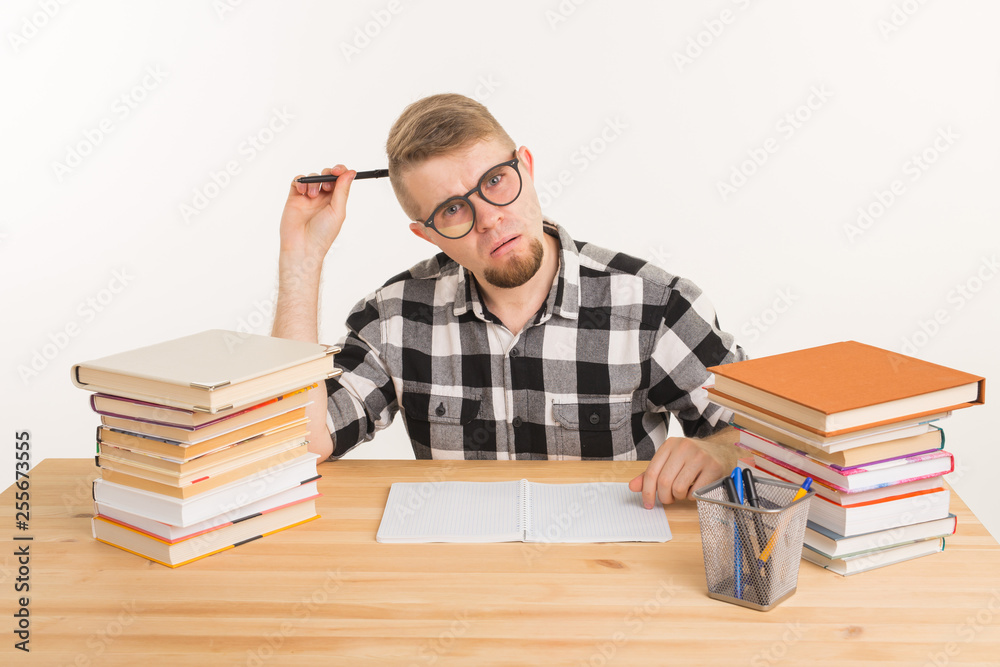 Education, knowledge and people concept - student in glasses thinking about exams and learning the literature Education, knowledge and people concept - student in glasses thinking about exams and learning the literature