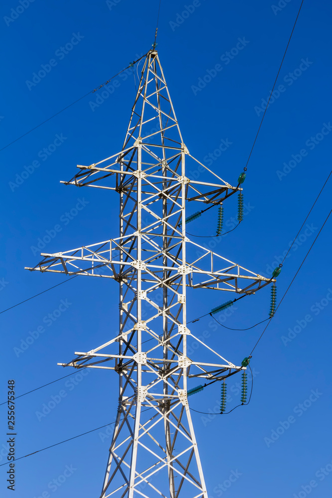 Power pole with glass insulators against a blue sky. Close-up. Power pole with glass insulators against a blue sky. Close-up.