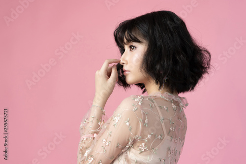 Portrait beautiful woman asian with clean skin, natural make-up,she used her nose,pink background