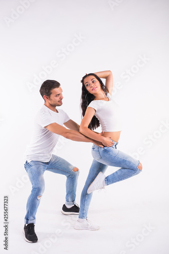 Young couple dancing social dance bachata, merengue, salsa, kizomba. Two elegance pose on white room.