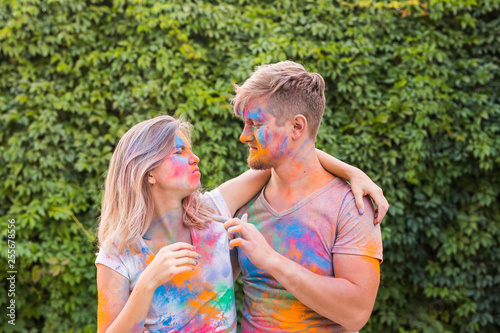 Holiday  holi and people concept - Happy couple having fun covered in paint