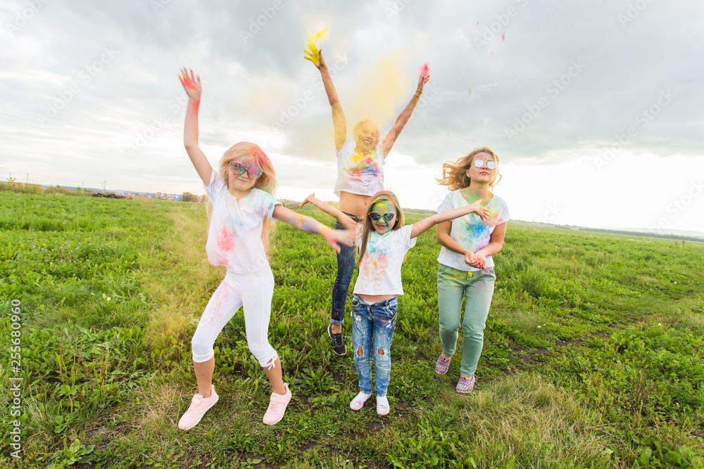 Festival of Holi, friendship and holidays concept - young female people on the color dancing and having fun Festival of Holi, friendship and holidays concept - young female people on the color dancing and having fun