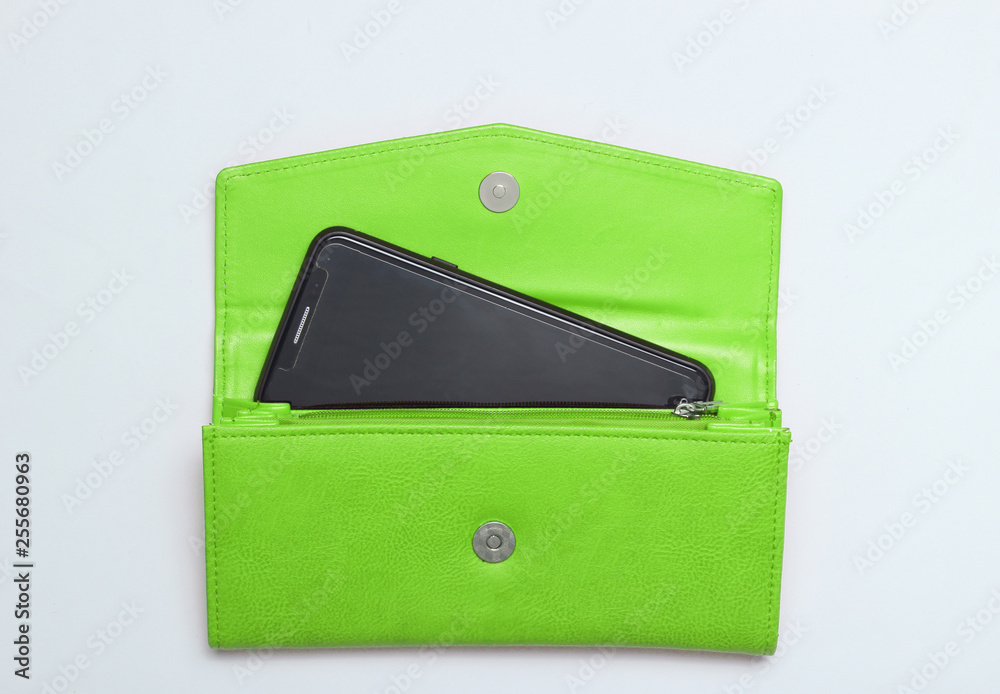Smartphone in green leather wallet on a white background. Top view. Smartphone in green leather wallet on a white background. Top view.