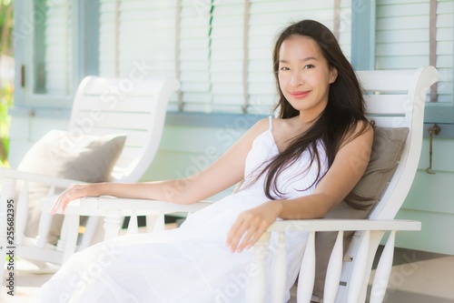 Portrait beautiful young asian woman sit on wood chair around outdoor patio