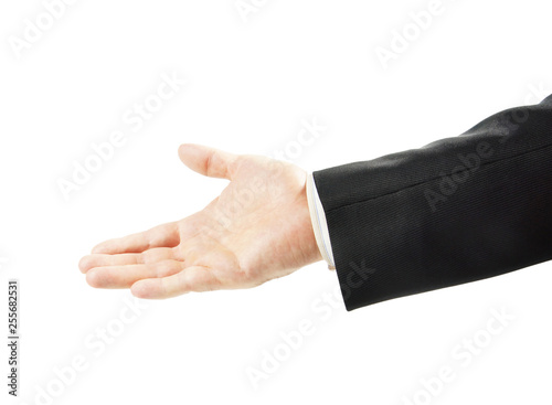 Friendly man in a suit reaches his hand out with an open palm up isolated on white background