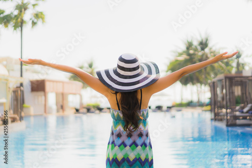 Portrait beautiful young asian woman happy smile and relax around swimming pool in hotel resort
