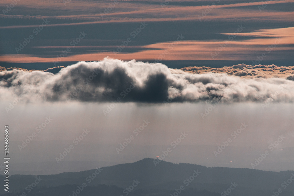 Beautiful sunreise on the hill above clouds and its raining