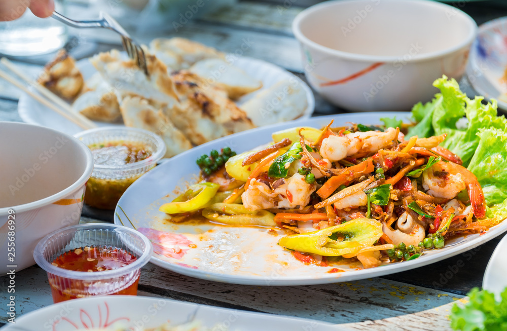 Close up view. Stir fried seafood in a plate placed on wooden table of restaurants by the sea.