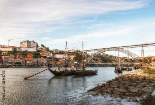 Ancient sailing vessels on Douro River. Dom Luis Bridge. Porto, Portugal.