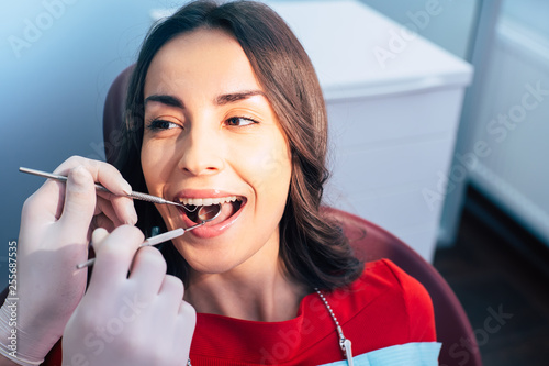Smile art. A girl in the dentist chair is getting some dental treatment without any pain but only with peasant feelings because of the professionalism of the doctor.