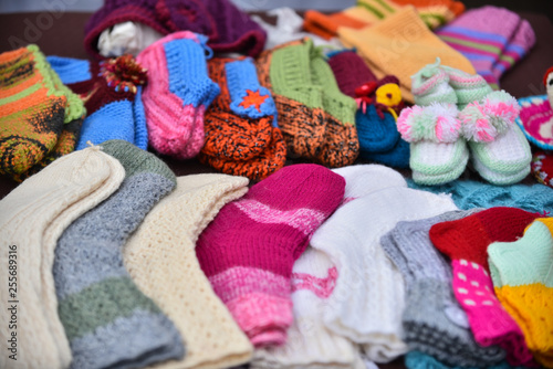 A row of multicolored hand-knitted baby socks © Raimonds Kalva