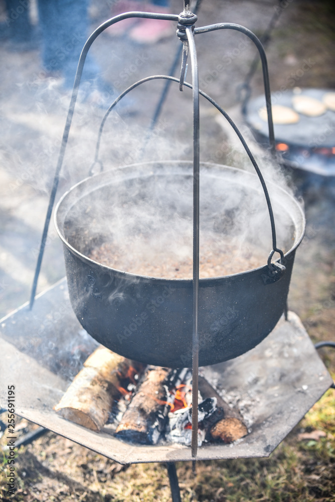Preparing food on campfire in wild camping Preparing food on campfire in wild camping