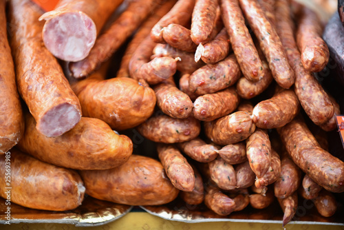 Delicious pieces of smoked sausage exposed for sale in the market. Selective focus and small depth of field