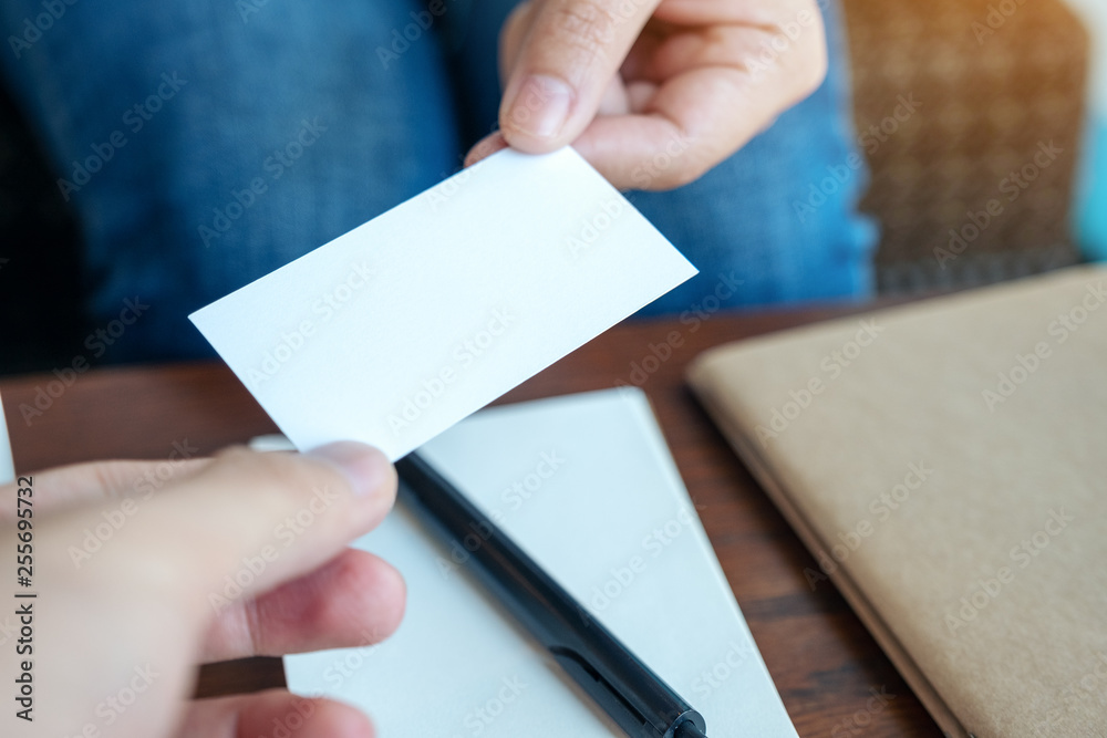 A woman holding and giving empty business card to someone