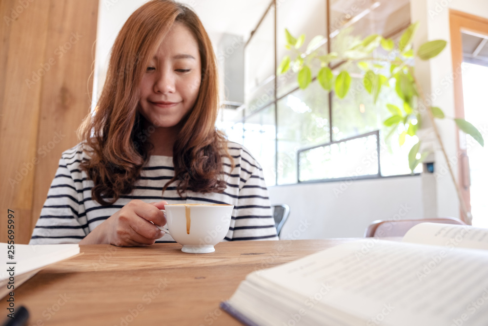 Closeup image of a beautiful asian woman drinking coffee while learning and reading books Closeup image of a beautiful asian woman drinking coffee while learning and reading books