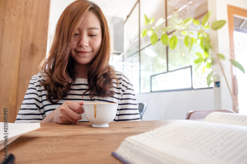 Closeup image of a beautiful asian woman drinking coffee while learning and reading books