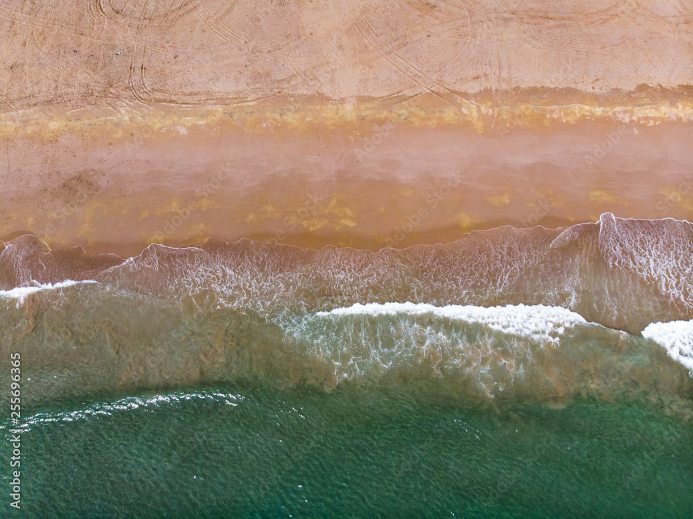 Fototapeta premium Waves splashing the sea shore aerial view