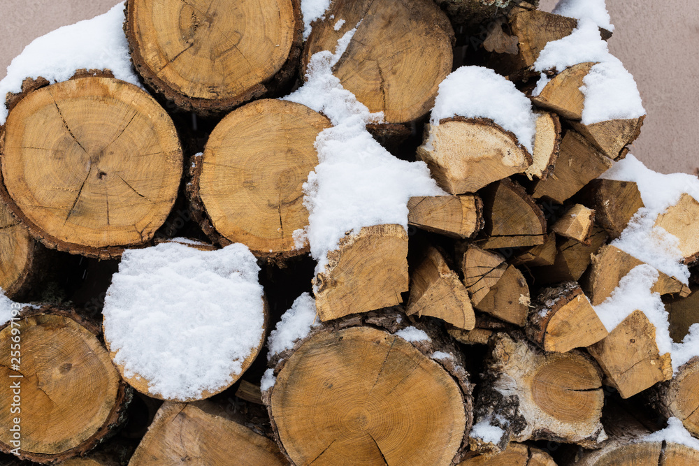 Chopped stock of firewood under snow on the street. Firewood for fireplace and bbq Chopped stock of firewood under snow on the street. Firewood for fireplace and bbq