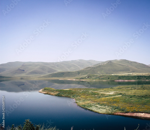 Scenery Lake surrounded by mountains and green fields in Armenia