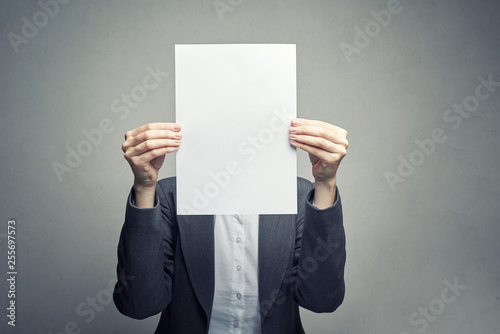 anonymous woman covering face with  paper sheet photo