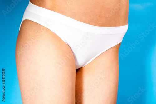 Close up photo of woman's belly and white panties