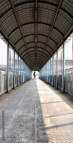 woman walking between frame made by crossing bridge