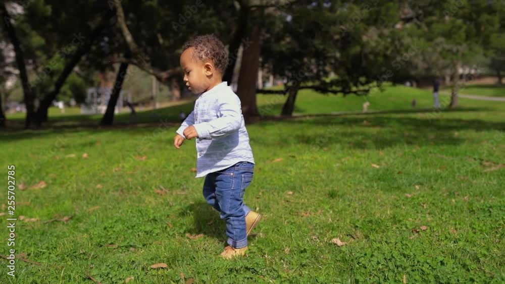 Little mixed-race boy playing with ball in park, trying to playing pass, smiling. Family, game concept Little mixed-race boy playing with ball in park, trying to playing pass, smiling. Family, game concept