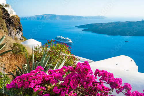 Santorini island, Greece. White architecture and pink flowers with sea view.