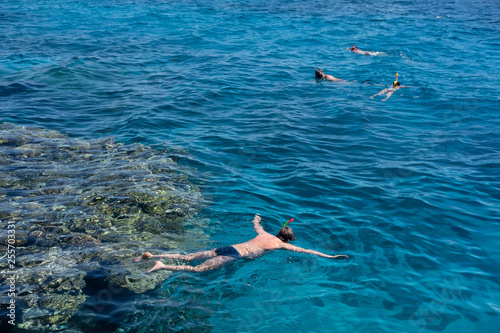 tourists snorkel in crystal turquoise water