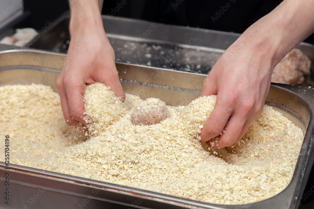 Chef hands creating, forming, breading chicken cutlet with knife on professional restaurant kitchen. Concept fast food business, preparation for cooking, menu, gastronomy, burgers, patty, meatballs Chef hands creating, forming, breading chicken cutlet with knife on professional restaurant kitchen. Concept fast food business, preparation for cooking, menu, gastronomy, burgers, patty, meatballs