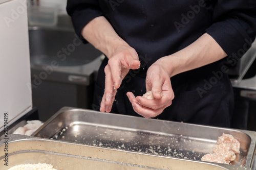 Chef hands creating, forming, breading chicken cutlet with knife on professional restaurant kitchen. Concept fast food business, preparation for cooking, menu, gastronomy, burgers, patty, meatballs