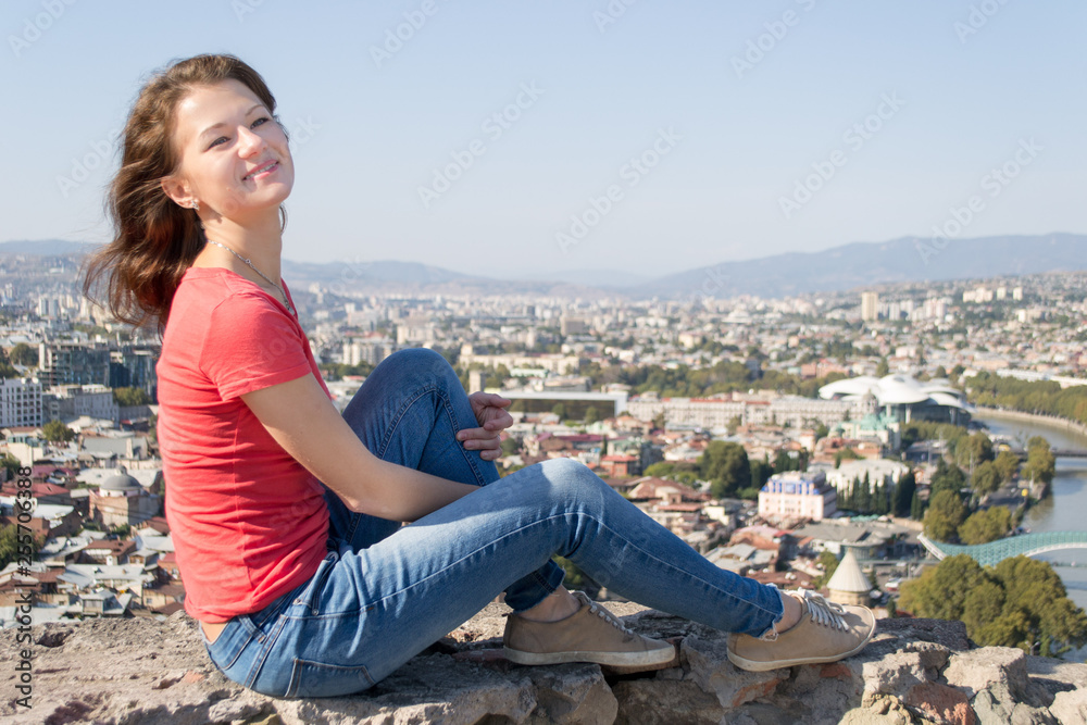 young woman sitting on a rock