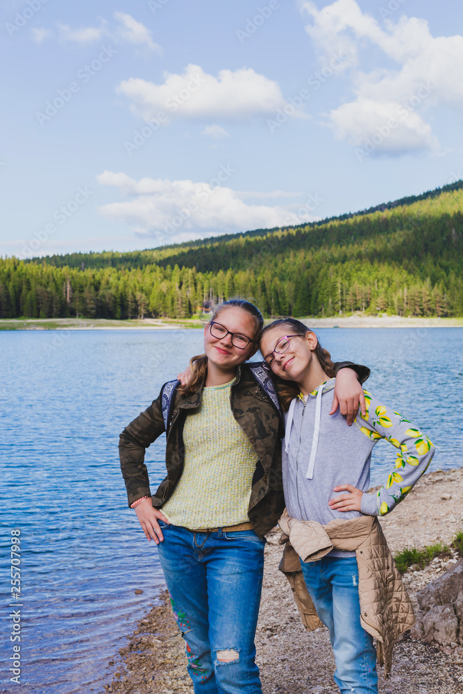 Funny Caucasian teenagers by the lake on a background of hills in Zabljak Montenegro on a sunny day. Funny Caucasian teenagers by the lake on a background of hills in Zabljak Montenegro on a sunny day.