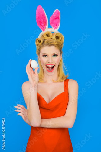 Happy Easter! Spring holiday. Happy girl with rabbit ears holds white egg. Egg hunt. Easter bunny. Easter concept. Woman witn bunny ears. White eggs. Bunny girl.