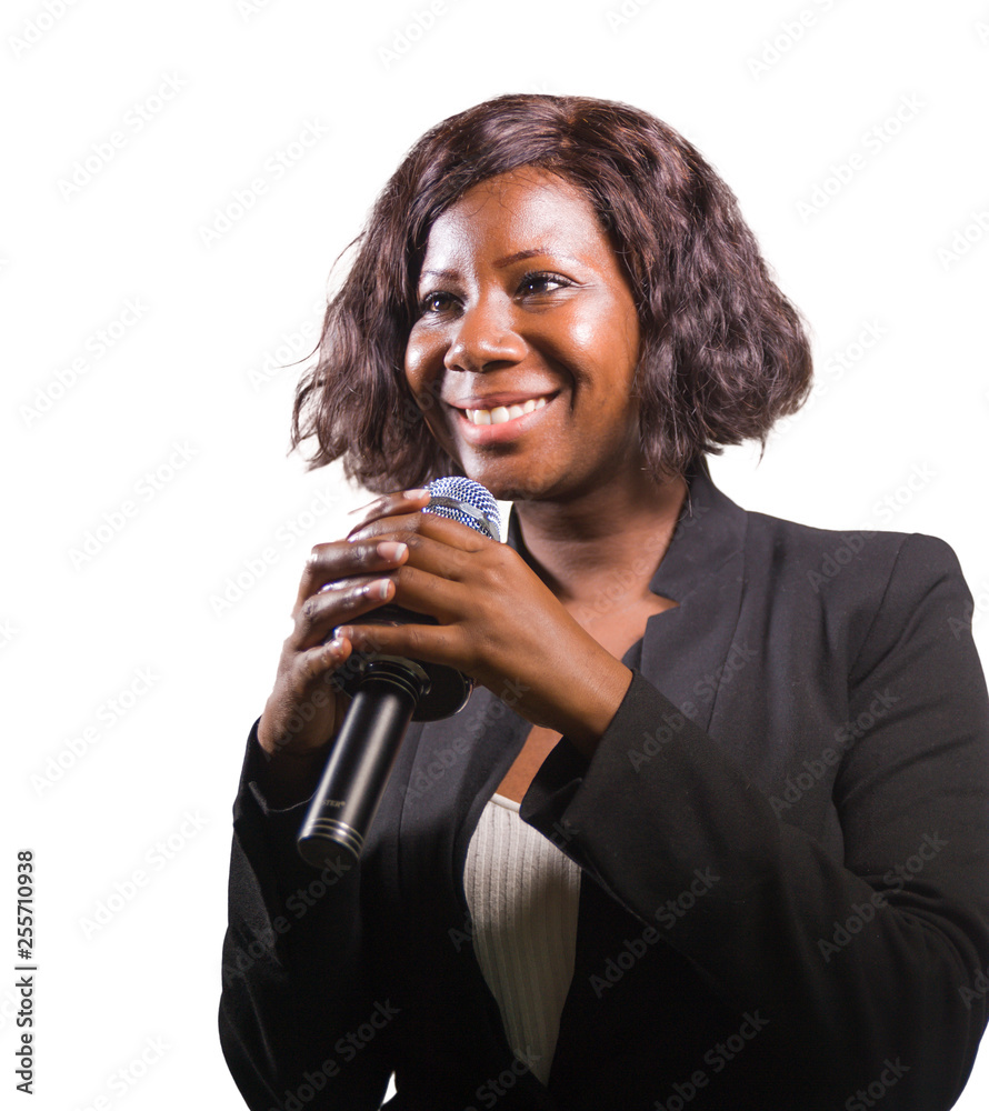 confident black African American business woman with microphone speaking in auditorium at corporate event or seminar giving motivational coaching speech isolated confident black African American business woman with microphone speaking in auditorium at corporate event or seminar giving motivational coaching speech isolated