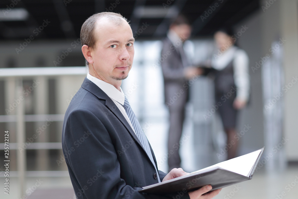 close up.serious businessman reading business document. standing in the office. close up.serious businessman reading business document. standing in the office.