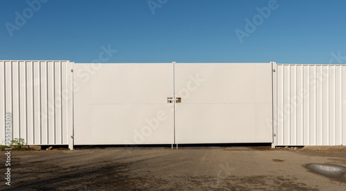 Gateway in white metal fence