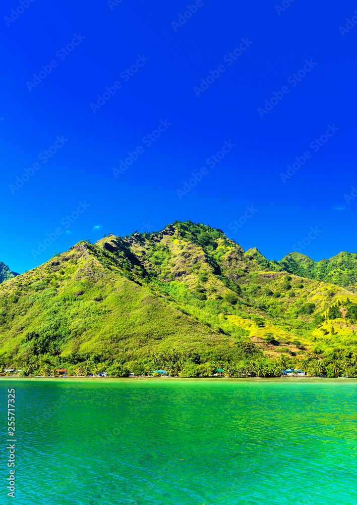 View over turquoise tranquil coral ocean an the mountain landscape, Moorea island, French Polynesia. Vertical. Copy space for text.