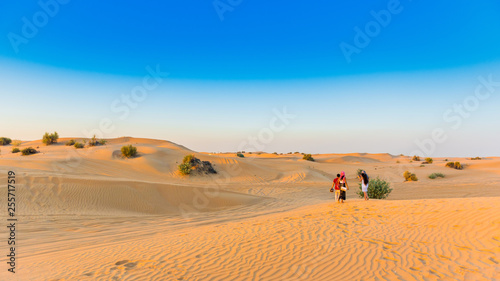 Couple over sand dunes during a jeep safari in Dubai Desert Conservation Reserve  United Arab Emirates. Copy space for text.