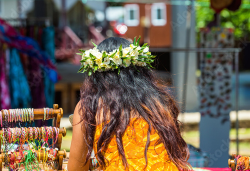 Girl with a white wreath of flowers, Rarotonga, Aitutaki, Cook Islands. With selective focus. Back view. photo
