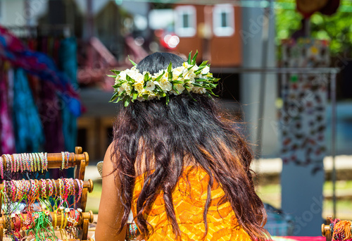 Girl with a white wreath of flowers, Rarotonga, Aitutaki, Cook Islands. With selective focus. Back view.