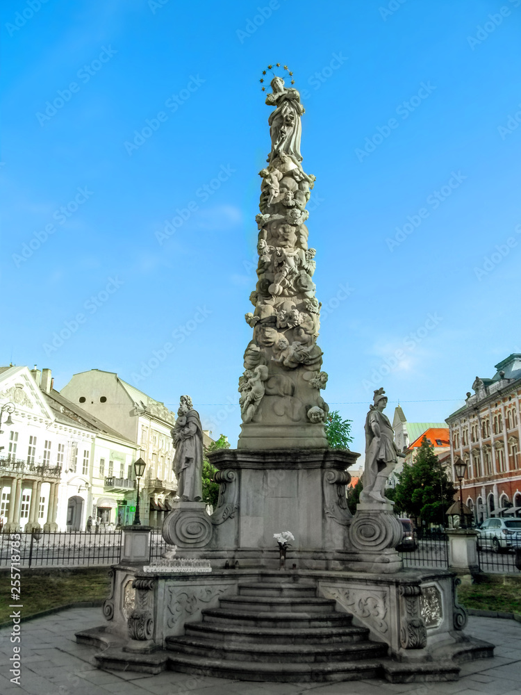 Fototapeta premium Koszyce, Republika Słowacka - 2 maja 2018: Kolumna Maryjna i Świętej Trójcy w Koszycach, zbliżenie, vectical. Filar zarazy na tle miejskiego krajobrazu małego średniowiecznego miasteczka
