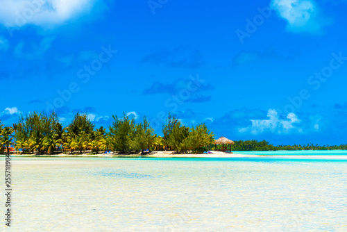 Stunning tropical Aitutaki island with palm trees, white sand, turquoise ocean water and blue sky at Cook Islands, South Pacific. Copy space for text.
