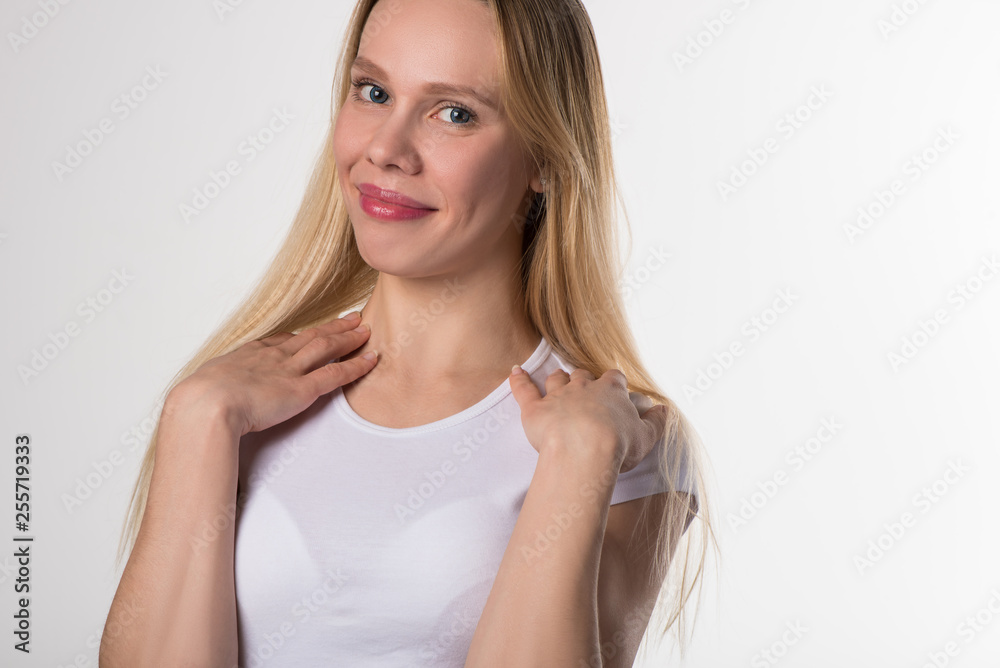 Portrait of a blonde girl with brown eyes in blue soft contact lenses on a white background