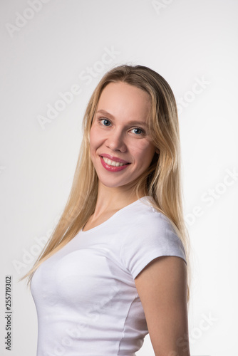 Portrait of a blonde girl with brown eyes in blue soft contact lenses on a white background