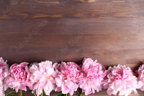 peony flowers frame on wooden background. space for a text  flat lay.