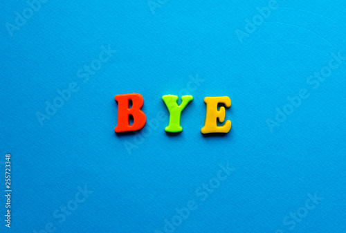 word bye from plastic magnetic letters on blue background